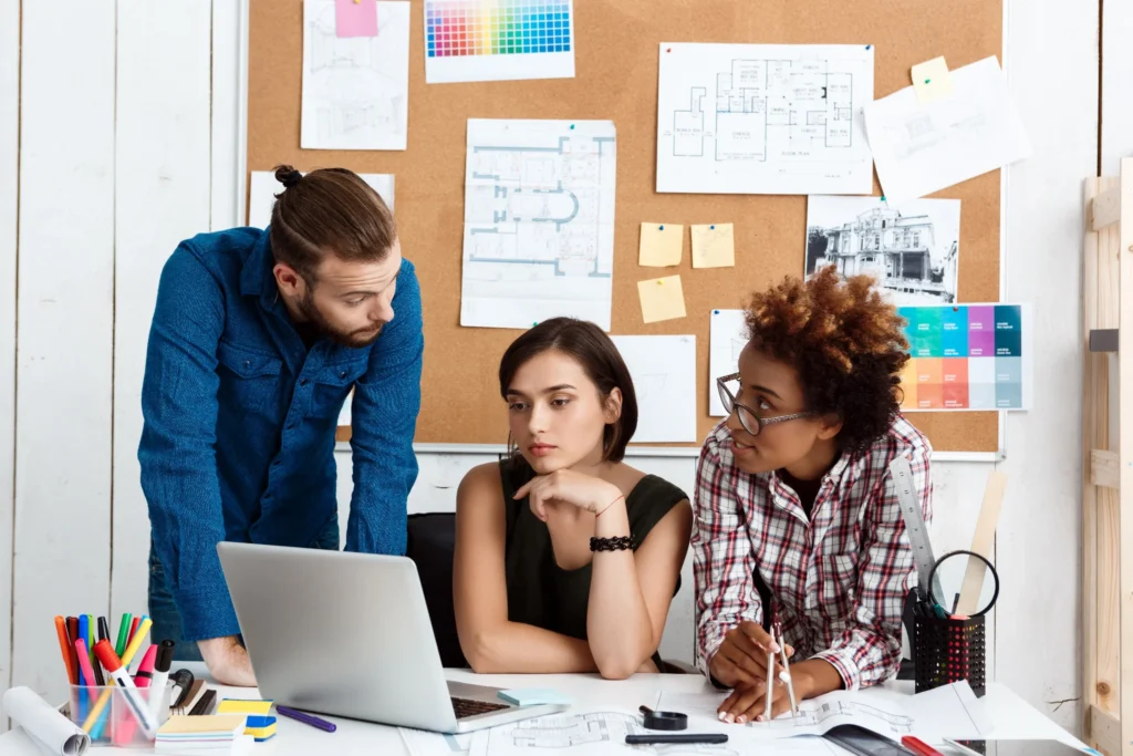 Equipe colaborando em frente a um notebook, analisando informações e planejamentos de forma clara e aberta, simbolizando transparência, organização e confiança no conteúdo digital.